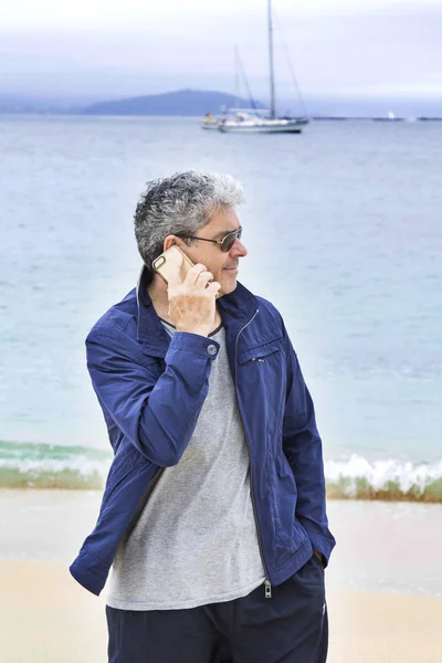 Старший чоловік з книгою на пляжі — стокове фото