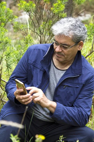 Hombre mayor en la montura usando el teléfono móvil — Foto de Stock