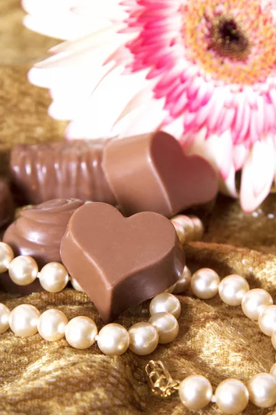 Sortimento de chocolates e colar de pérolas — Fotografia de Stock