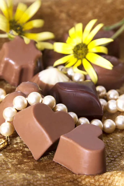 Sortimento de chocolates e colar de pérolas — Fotografia de Stock