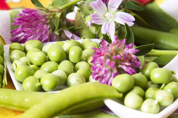 Plato con guisantes verdes y adornos de primavera —  Fotos de Stock