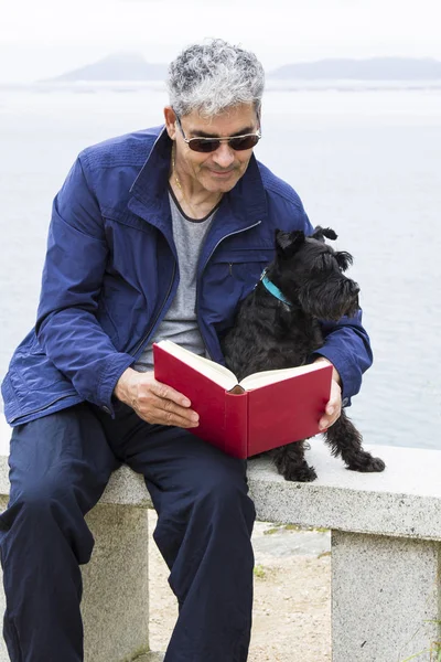 Senior man with book and dog