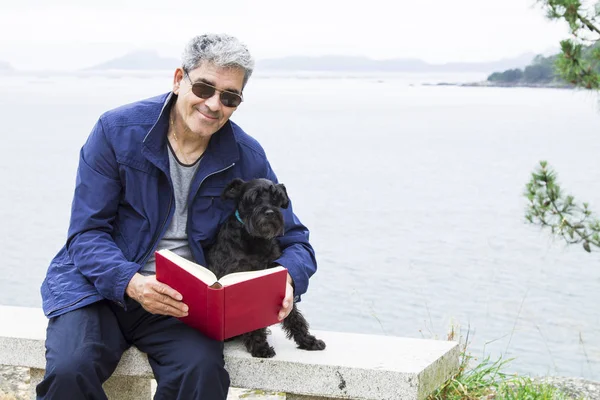 Senior man with book and dog