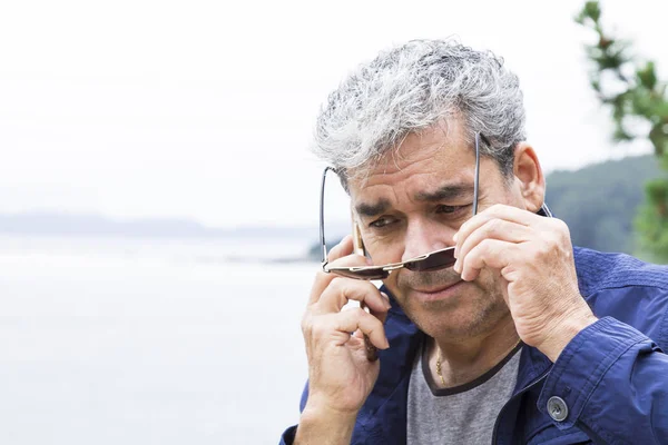 Homem sênior falando ao telefone na praia — Fotografia de Stock