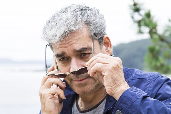 Homem sênior falando ao telefone na praia — Fotografia de Stock