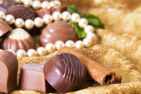 Sortimento de chocolates com colar de pérola — Fotografia de Stock