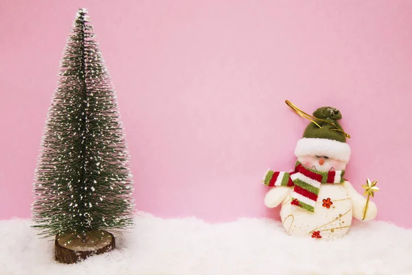 Snö man och jul granen på snö med färgbakgrund — Stockfoto