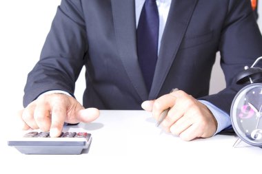 Ofiste hesap makinesi olan bir iş adamı var.