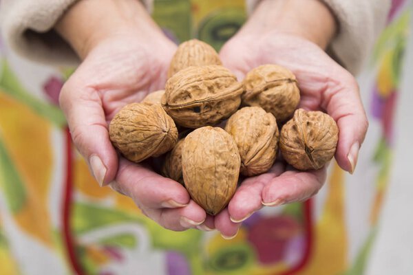 женщина держит в горсти орехов
