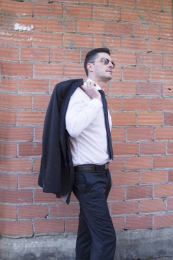 Erkek takım elbise ve tuğla arka plan ile
