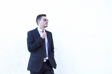 Takım elbise ve kravatını sabitleme güneş gözlüğü adam portresi