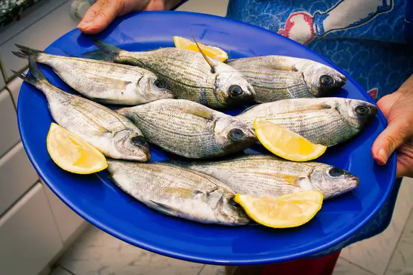 Žena Držící Rybí Pokrm Citronem — Stock fotografie