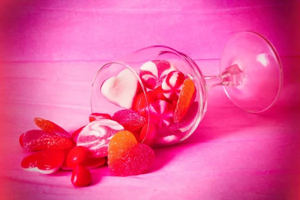 Glazen Beker Met Hartvormige Rubber Snoepjes Roze Achtergrond — Stockfoto