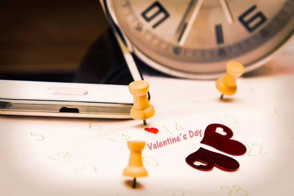 Valentine\'s concept. mobile phone and alarm clock with calendar