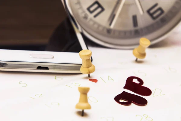 Valentine's concept. mobile phone and alarm clock with calendar