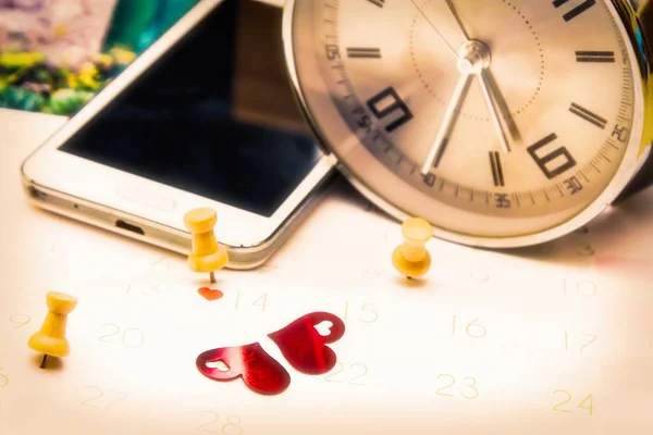 Valentine's concept. mobile phone and alarm clock with calendar