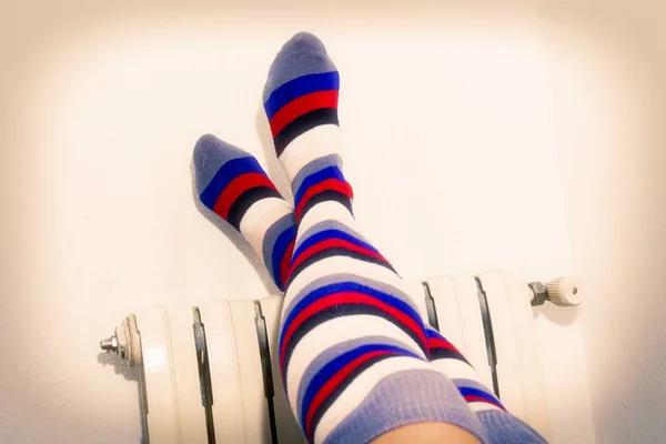 feet with striped socks on radiator