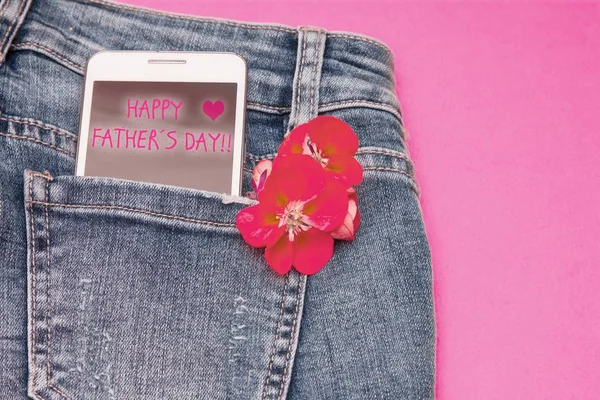 mobile phone in blue jeans pocket with father\'s day greeting