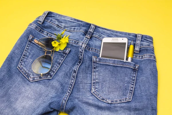 Óculos Sol Telefone Celular Flores Amarelas Bolso Azul Jeans — Fotografia de Stock