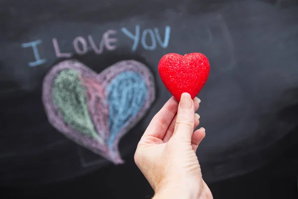 Hand Mit Herz Und Zeichenhintergrund Auf Tafel Konzept Des Valentinstages — Stockfoto