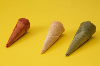 Sarı arka planda renkli dondurma külahları