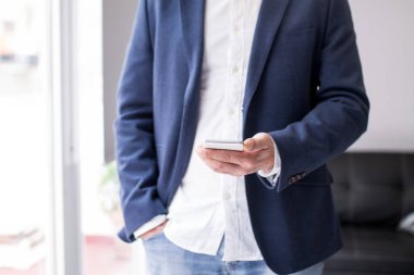 İş adamı ofisteki cep telefonunu kullanıyor.