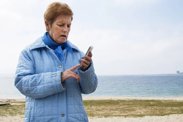 woman using the mobile phone with the sea in the background