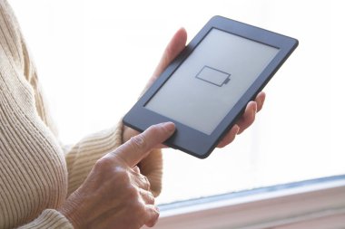 Evde dijital tablet ya da dizüstü bilgisayarlı yaşlı kadın