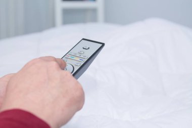 yataktan tv uzaktan kumanda kullanarak adamın eli