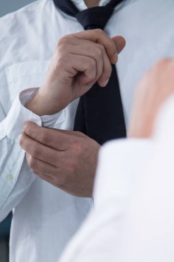 Adam aynanın önünde kelepçeleri bağlıyor.