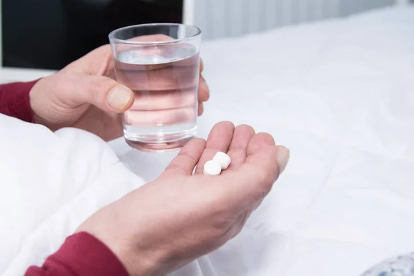 Mann Hält Glas Wasser Der Hand Und Schaut Auf Pille — Stockfoto