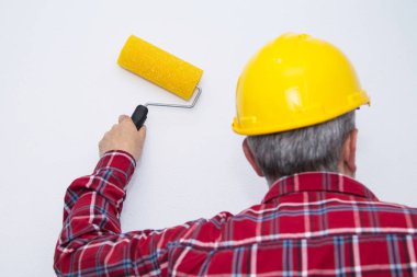 Duvarı silindirle boyayan ressam, dekorasyon ve yenileme konsepti