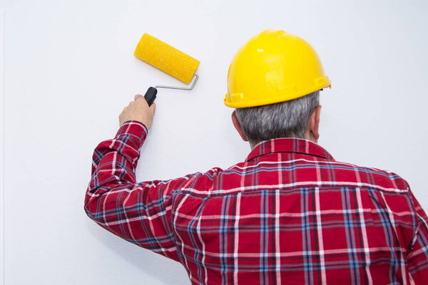 painter painting with roller the wall, concept of decoration and renovation