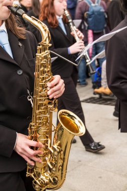 Müzik grubuyla saksafon çalan kadın.