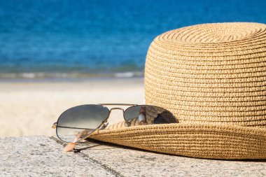 Plaj manzarasında şapka ve güneş gözlüğü, tatil ve yaz