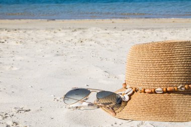 Plaj manzarasında şapka ve güneş gözlüğü, tatil ve yaz