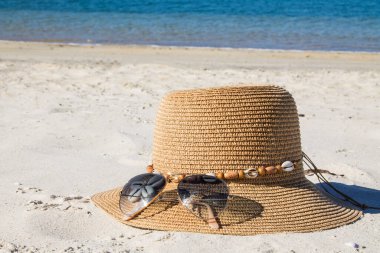 Plaj manzarasında şapka ve güneş gözlüğü, tatil ve yaz
