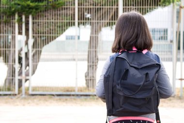 Sırt çantalı bir öğrenci okula ya da kampüse gidiyor, okula geri dönüyor.