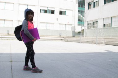 Sırt çantalı bir öğrenci okula ya da kampüse gidiyor, okula geri dönüyor.