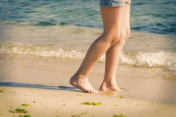 海岸沿いの少女の足は — ストック写真