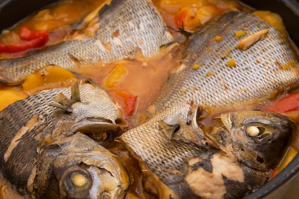 stewed fish casserole with potatoes on wood