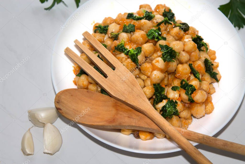 bowl of cooked chickpeas with spinach closeup view