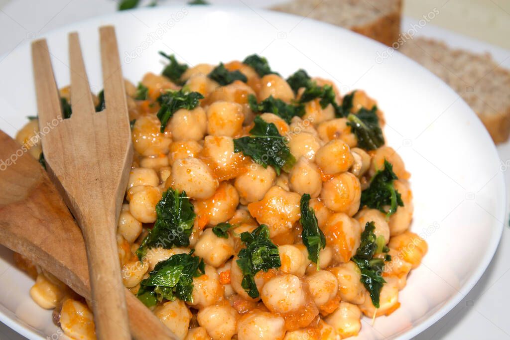 bowl of cooked chickpeas with spinach closeup view