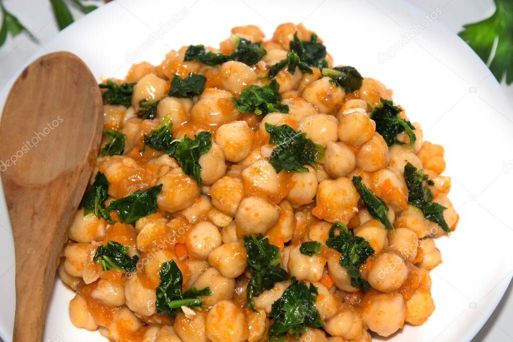 bowl of cooked chickpeas with spinach closeup view