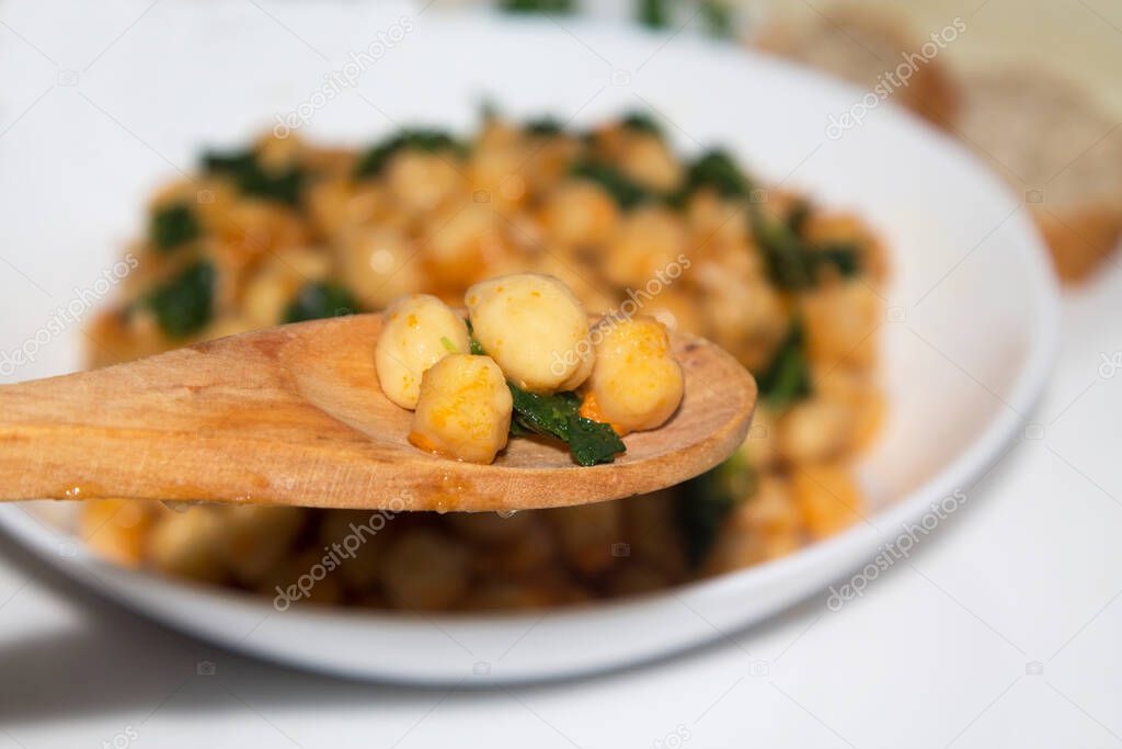 bowl of cooked chickpeas with spinach closeup view