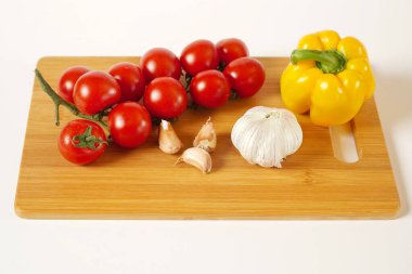 Tahtada domates, sarımsak ve biber, beyaz arka plan.