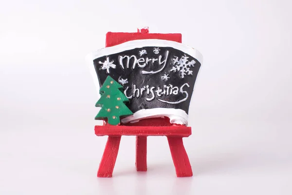 Kırmızı sehpa, beyaz arka planda Noel ağacı ve karatahta.