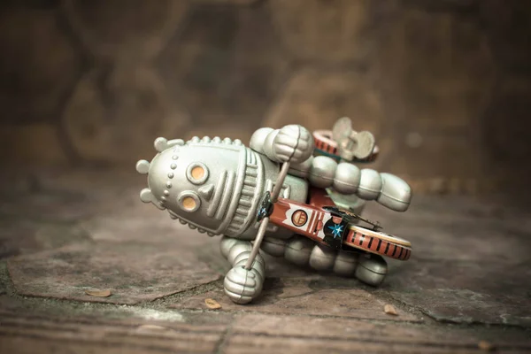 Old robot toy lost energy, vintage color style, vintage tone background.
