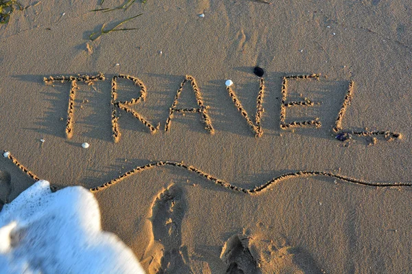 The word TRAVEL written on a sandy beach. — Stock Photo, Image