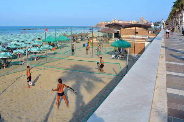 Termoli, Molise, Olaszország - 08 / 26 / 2019- A homokos strand a régi halászfaluval a háttérben. — Stock Fotó